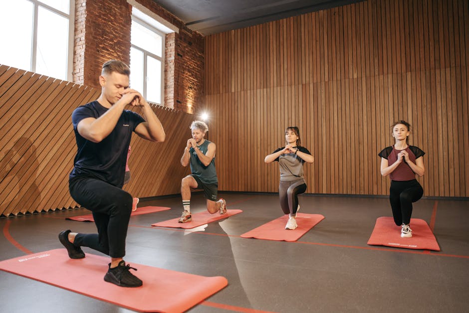 Adults practicing exercises on yoga mats in a contemporary studio setting