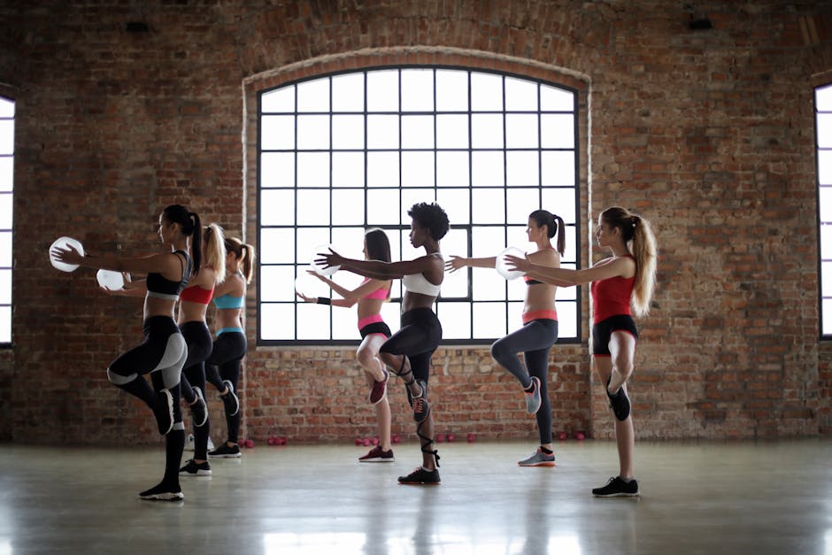 Women practicing yoga poses in a brick-walled studio, promoting fitness and flexibility.